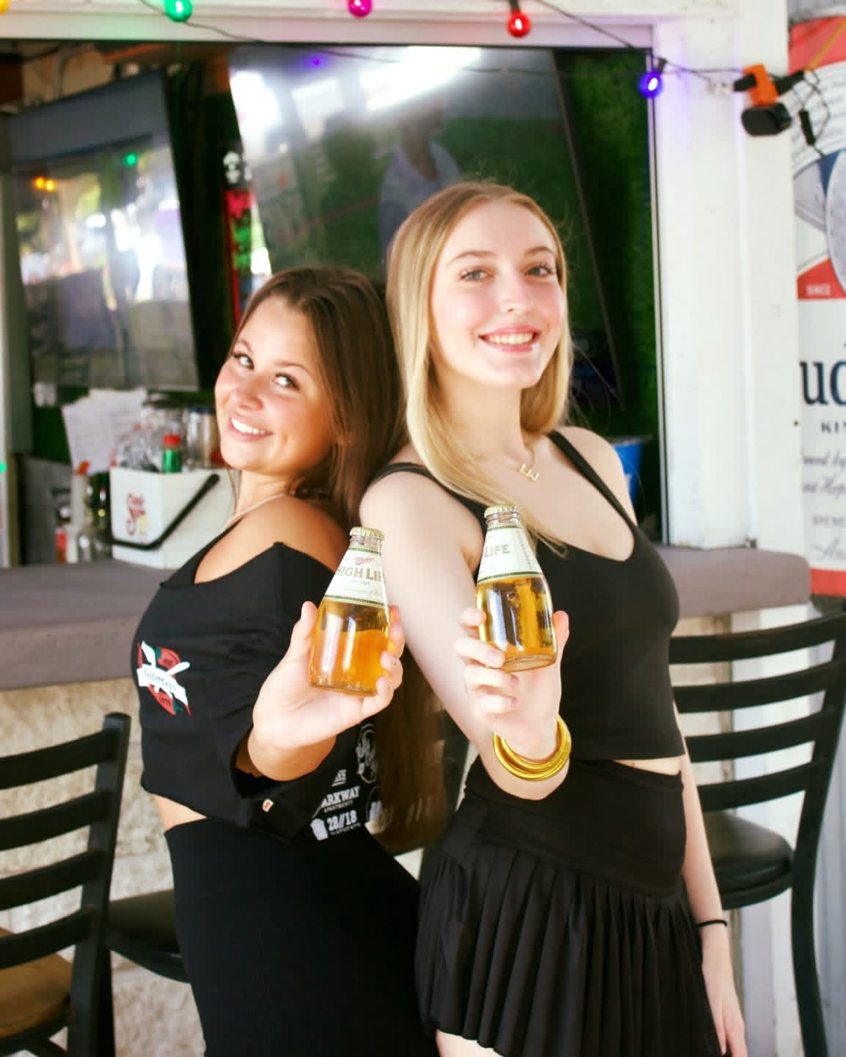 Two friends holding Miller High Life bottles